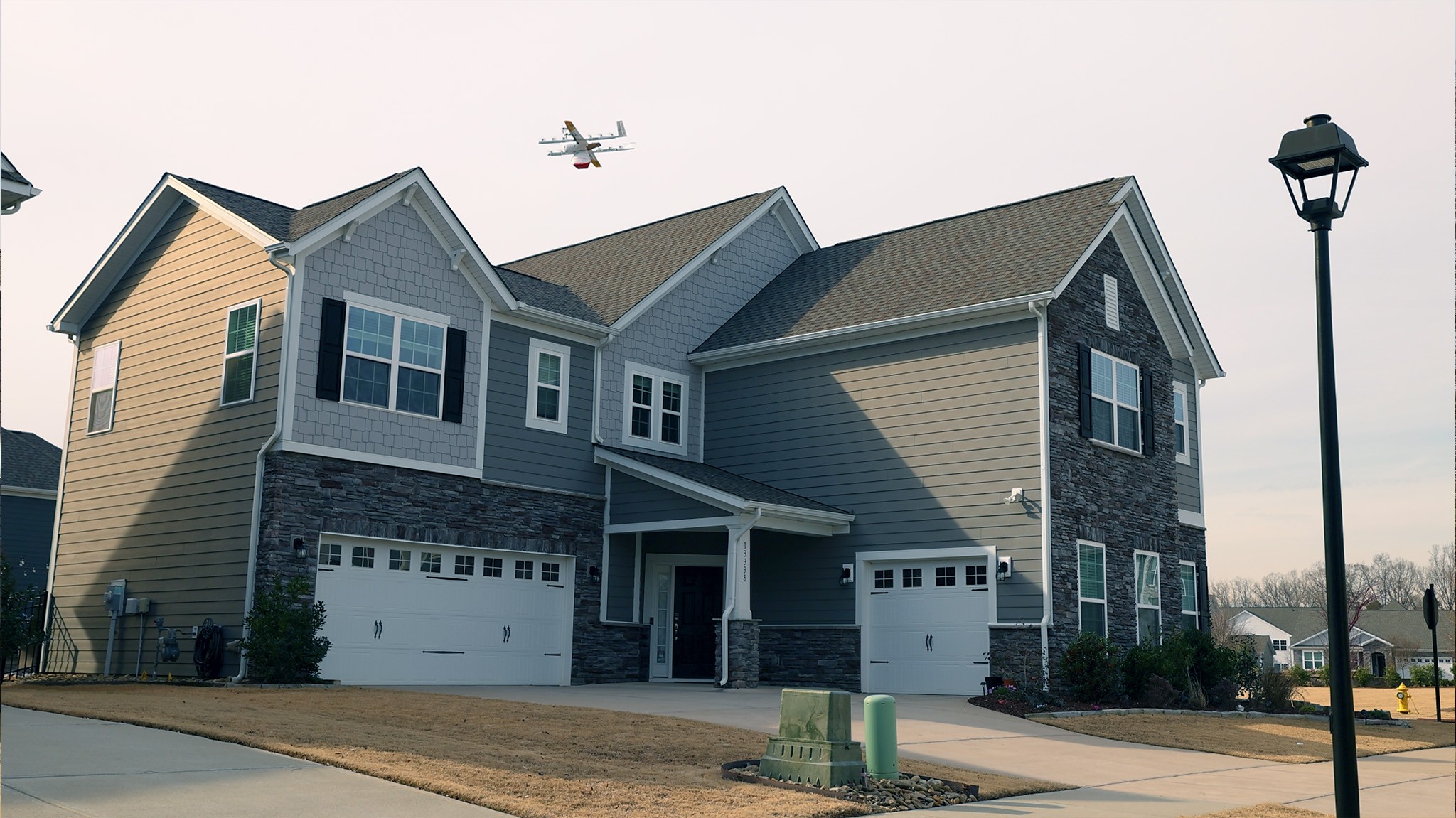 Wing delivery drone lowers package to Charlotte home. 